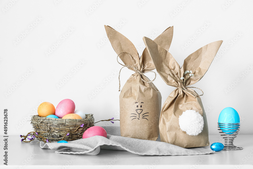 Paper bags bunny with Easter eggs on table in room