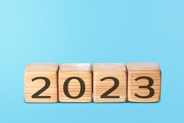 Poster - Flipping wooden cubes 2022 to 2023 with blue background. Happy new year 2023.