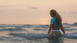 © ivandanru - SLOW MOTION GLOW MIST DARK SILHOUETTE CINEMATIC VIEW: Sexy hot woman standing on water sea. Girl stand in turquoise swimsuit. Freedom paradise holiday vacation summer beach, seaside landscape concept