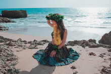 Hawaiian Woman Waves To The Camera And Smiles Relaxed On A Paradisiacal Beach. Oriental And Exotic Beauty.
