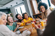 Multiethnic diverse extended family dining and toasting together