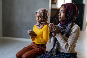 Wall Mural - Muslim family praying together. Religious activity concept