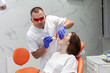 © splitov27 - Professional dentist whitens teeth with device, lamp for whitening teeth to woman patient in dental clinic