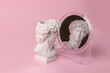 © splitov27 - Bust of David admires himself looking in a mirror on a pink background. Narcissism. Minimal still life