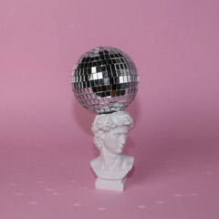 Wall Mural - Bust of David with a disco ball on a pink background. Minimal party concept. Creative contemporary still life