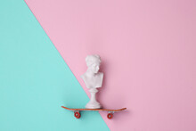 Venus Bust With Skateboard On Pink Blue Background. Minimal Contemporary Still Life. Top View