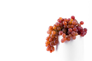 Wall Mural - Grapes on podium. Bunch of Grapes on white ceramic platform on light background. clos up image