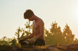 © Thiago Gomes - Young man doing yoga at the sunrise on a top of a mountain next the trees over the rocks