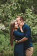 © Дмитрий Ткачук - Handsome young guy with a girl stand in the spring garden. Romantic couple are walking in the park. Happy relationship concept