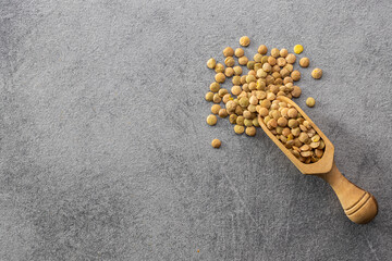 Poster - Uncooked brown lentils. Raw legume in wooden scoop.