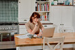 © Tinashe Njaku/peopleimages.com - I have so many bills to pay. Shot of a woman sitting at home with paperwork and her laptop.