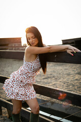 Wall Mural - Girl with long black hair in the countryside. Ipadrome with horses. Rural landscapes, wild west.