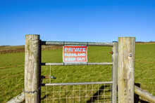 Private Keep Out Sign On A Metal Gate In A Fence Around Farmland. No People.