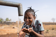 Close-up Of A Beautiful African Girl Washing Her Face At The Public Community Water Point; Social Issue Of Water Shortage And Inadequate Distribution
