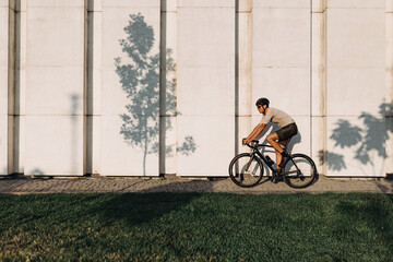 Caucasian man in sport clothes riding bike on city street