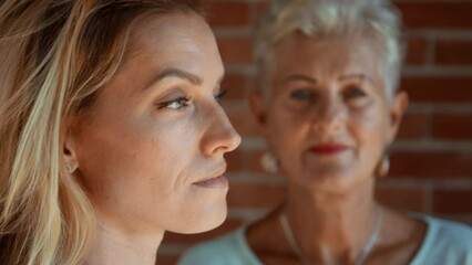 Wall Mural - Senior mother looking at her adult daughter indoors at home. Selective focus.