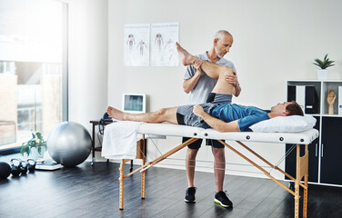 Wall Mural - How does it feel now. Shot of a physiotherapist treating a patient.