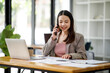 © David - Asian young businesswoman working in the office with laptop computer, doing planning analyzing the financial report, business plan investment, finance analysis concept
