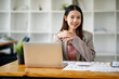 © David - Asian young businesswoman working in the office with laptop computer, doing planning analyzing the financial report, business plan investment, finance analysis concept