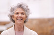 © D M/peopleimages.com - Retirement suits her. Portrait of a smiling senior woman standing outside.