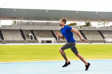 Sticker - Hes quick. Full length shot of a handsome young male athlete running along the track.