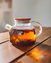 Transparent Glass Teapot Pour Black Tea. Glows In The Sun The Last Rays