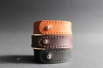 close-up of 3 leather bracelets in black, brown and red colors. Bracelets made of genuine leather, handmade.