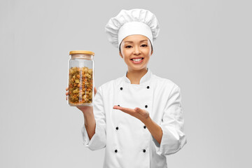 Poster - cooking, culinary and people concept - happy smiling female chef holding jar with pasta over grey background