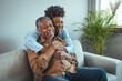 © Dragana Gordic - Smiling young woman sitting on sofa with happy older retired 70s father, enjoying pleasant conversation together in living room, mature parents and grown children communication.