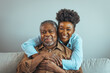 © Dragana Gordic - Afro hispanic-latino father and daughter together at home. Family is everything - Family Tie. Adult Daughter Hugging Senior Man. Senior black man and his middle aged daughter embracing, close up