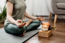 Young Relaxed Woman Doing Yoga At Home With Candles And Incense, Close-up Of Hands