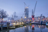 Fototapeta Miasto - Rotterdam, The Netherlands, January 12, 2022: pontoon bridge, cranes and historic vessels at the maritime outdoor museum on a misty morning