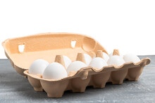 White Chicken Eggs In Carton Box On Grey Textured Background
