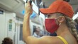© ivandanru - Woman travel caucasian ride at overground train airtrain with wearing protective medical red mask. Girl tourist at airtrain with respirator. Pandemic virus Coronavirus covid-19. People in mask.