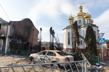 Wall Mural - Damaged church and burned car on the outskirts of Irpin