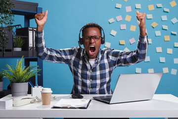 Wall Mural - customer support operator celebrating successful day at work by clenching fists in triumph. helpline