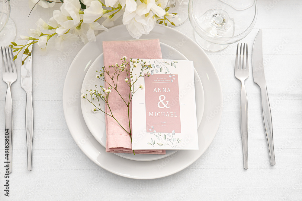 Stylish table setting with wedding invitation and gypsophila flowers