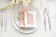 Stylish table setting with wedding invitation and gypsophila flowers