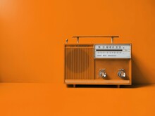 Old Transistor Radio, Orange Wall Background. Listen Music Concept