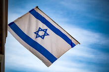 Israeli Flag Against Blue Sky And White Clouds