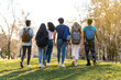 © Marc Calleja - Back view of a row of young multi-ethnic students walking together in the park