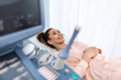 Happy pregnant female visiting women's doctor in the maternity center, doing ultrasound scan, worried about the health of the child, healthy motherhood concept