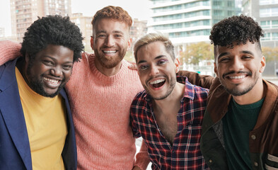 group of young diverse men smiling on camera in the city - multiracial male friendship concept