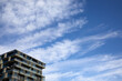Nowoczesny apartamentowiec na tle błękitnego nieba z chmurami