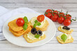 Crunchy crackers with cream cheese, tomatoes and olives.
