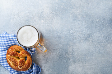 Wall Mural - Bavarian pretzels and glass of lager beer. Oktoberfest food menu, traditional salted pretzels on light grey background. Top view with space for text. Oktoberfest theme