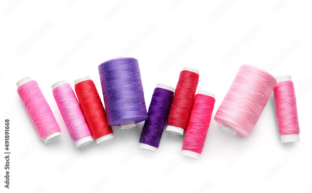 Different thread spools on white background
