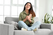 © Pixel-Shot - Happy young Asian woman after reading message from her boyfriend sitting on sofa at home
