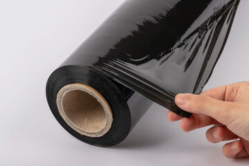 Roll of plastic cling film with black wrap. how long the roll of cling film can stretch is shown. It stands in an isolated environment. It is used in the packaging of products.