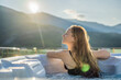 © galitskaya - Portrait of young carefree happy smiling woman relaxing at hot tub during enjoying happy traveling moment vacation life against the background of green big mountains
